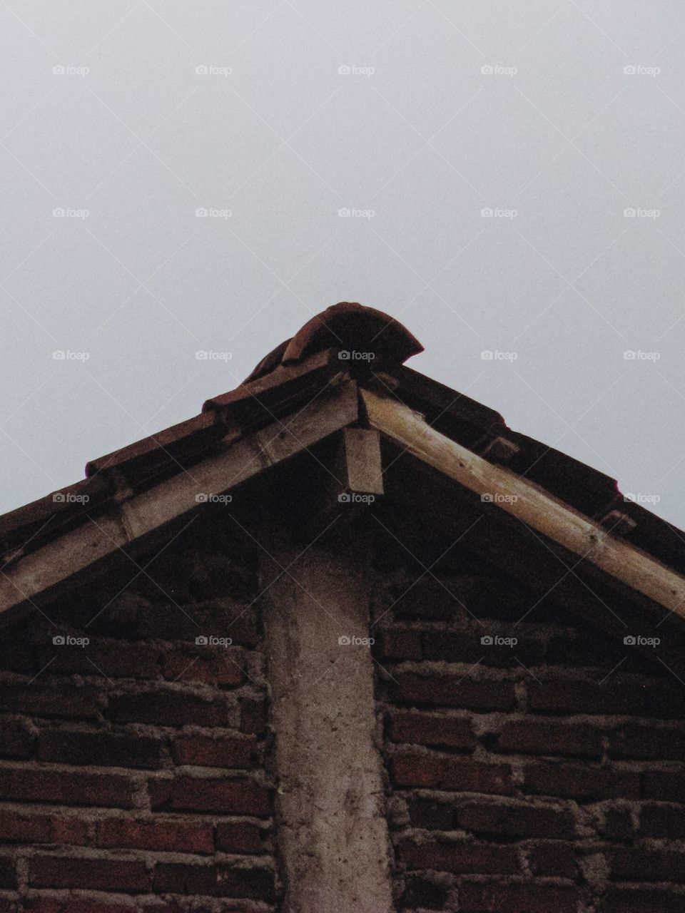 the top of an old building with brick walls and a damaged roof