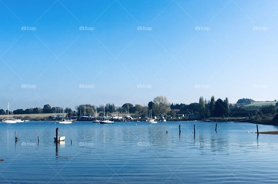 A beautiful riverside view on a crisp cool day. Blue skies and a beautiful, sparkling river. Boats to be seen in the distance.