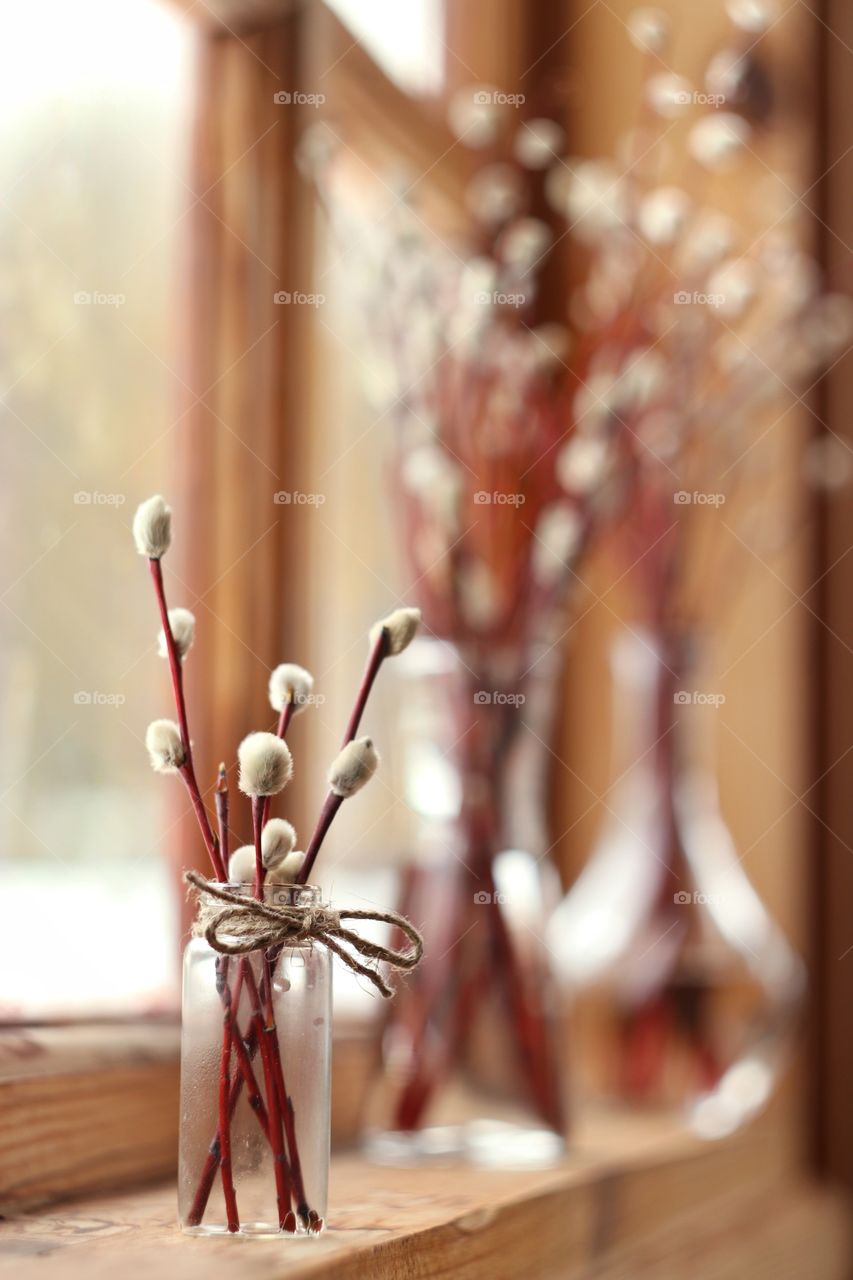 Willow branches in a glass vase on a wooden window