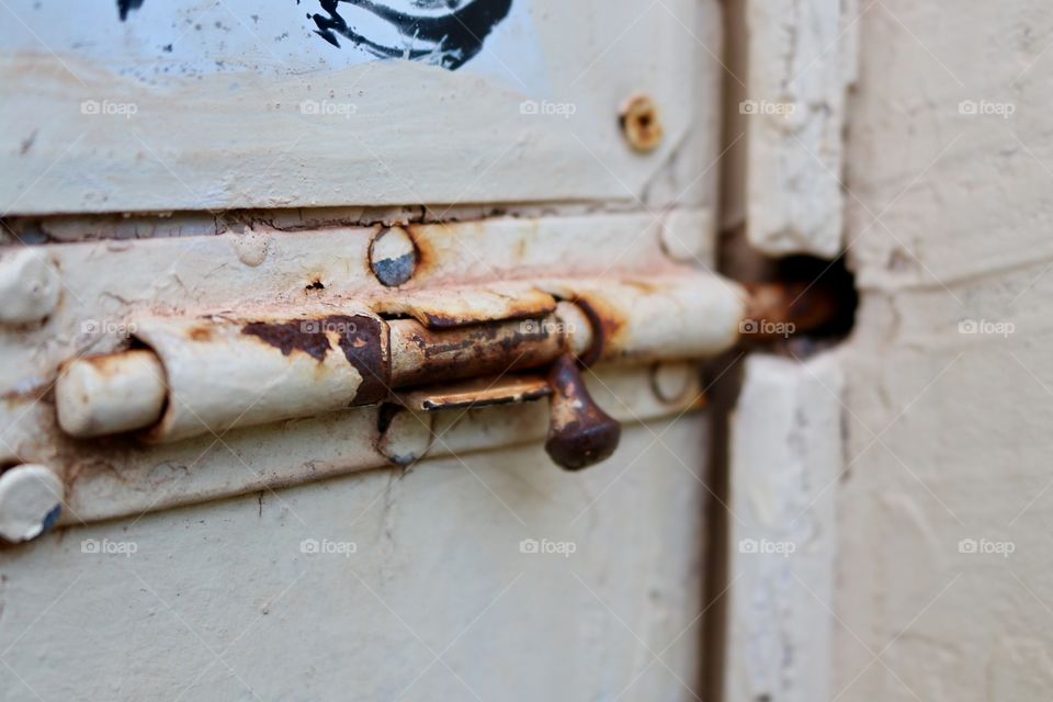 Rusty old sliding lock on old door closeup