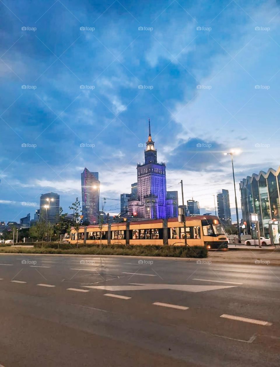 "City Tram with Illuminated Skyscrapers at Dusk"