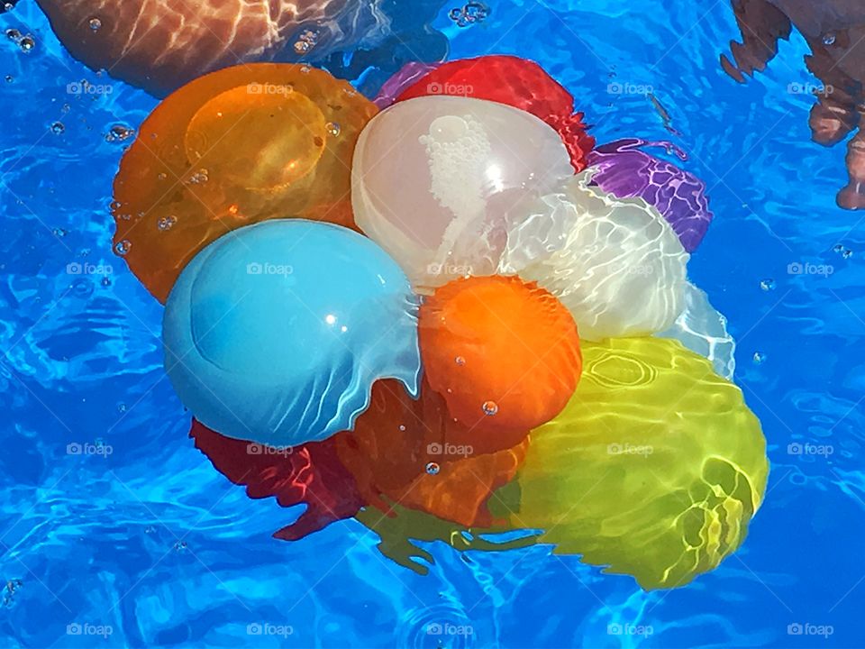 A bunch of floating colour. Floating colourful water balloons in the swimming pool