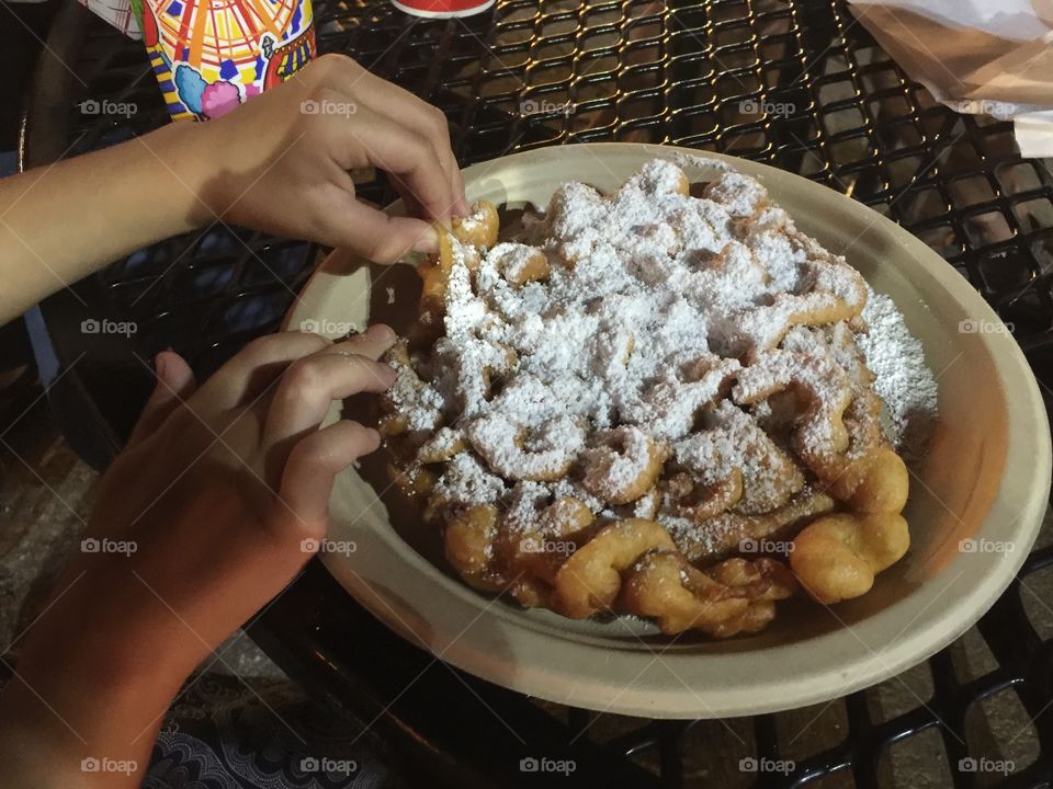 Delicious fried funnel cake topped with powdered sugar. 