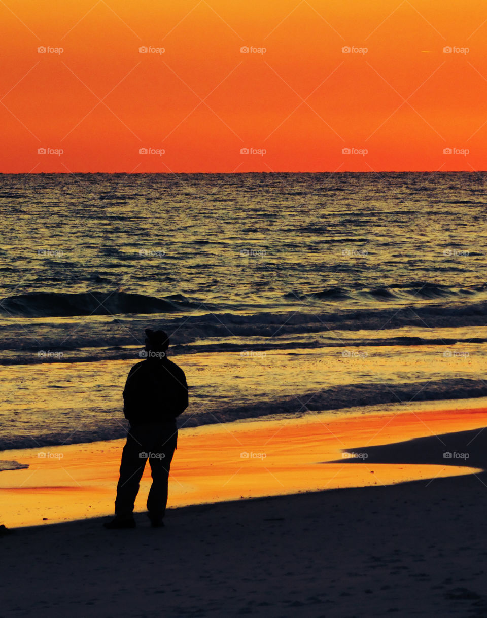 Sunset! A man with deep thoughts strolls along the silvery sand of the Gulf of Mexico!