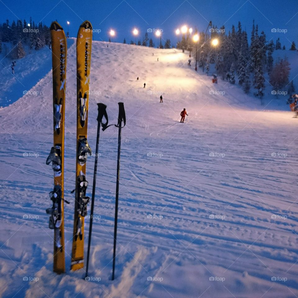 Ski slope in the evening. Alpine ski's at bottom of ski slope in evening