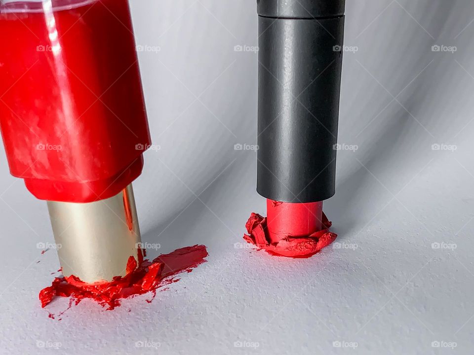 Upside down, crushed red lip sticks against white with long shadows