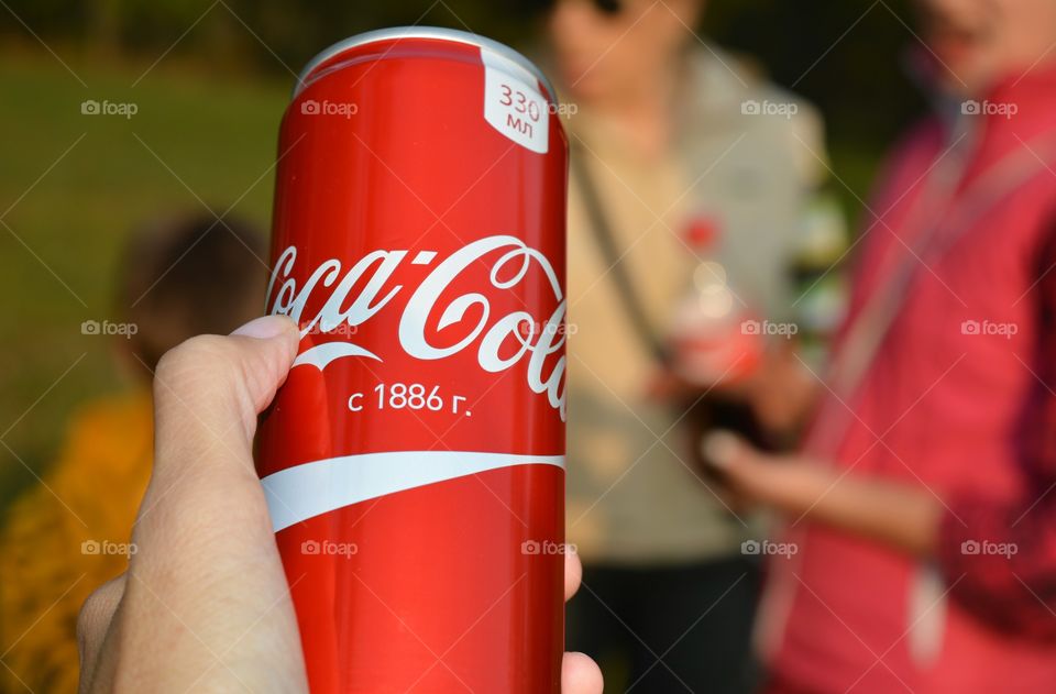 coca cola in hand and people, drinking coca cola outdoor