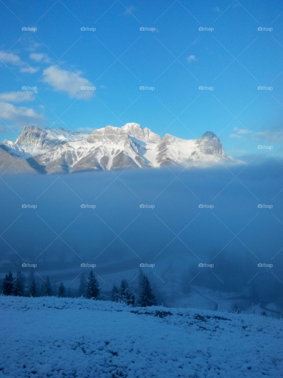 mountains above the cloud. Beautiful sunlit mountains raising over cloud