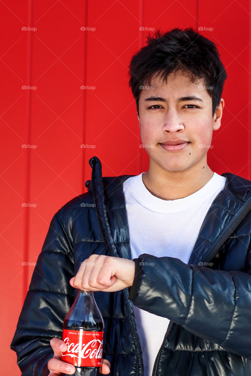 Young handsome man with a bottle of Coca-Cola