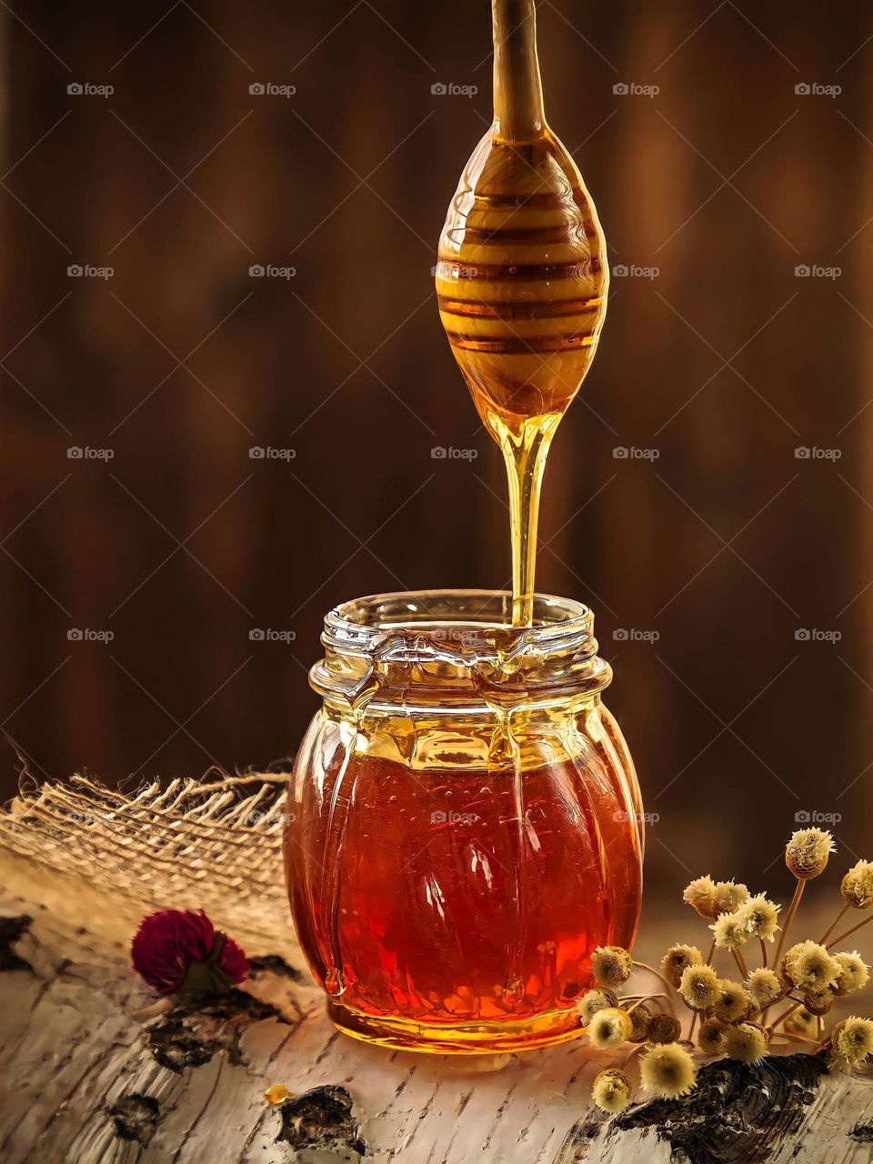 Honey dripping from dripper into the glass jar
Honey dripping from dripper into the glass jar on blurred background.