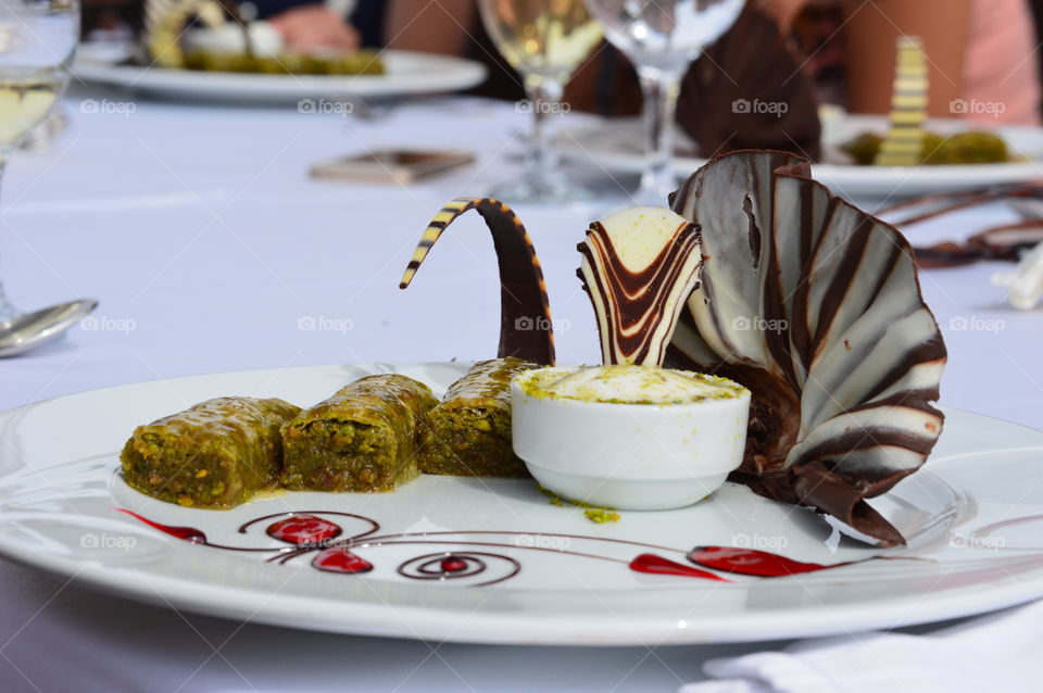 dessert, baklava and ice cream on a plate, decorated with chocolate