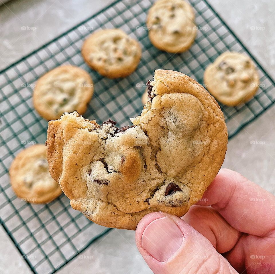 Happiness is that first bite of a chocolate chip cookie, happiness is sweet treats, happiness found in desserts, desserts make me happy, cookies make me happy, woman’s hand holding a cookie, taking a bite out of a delicious cookie