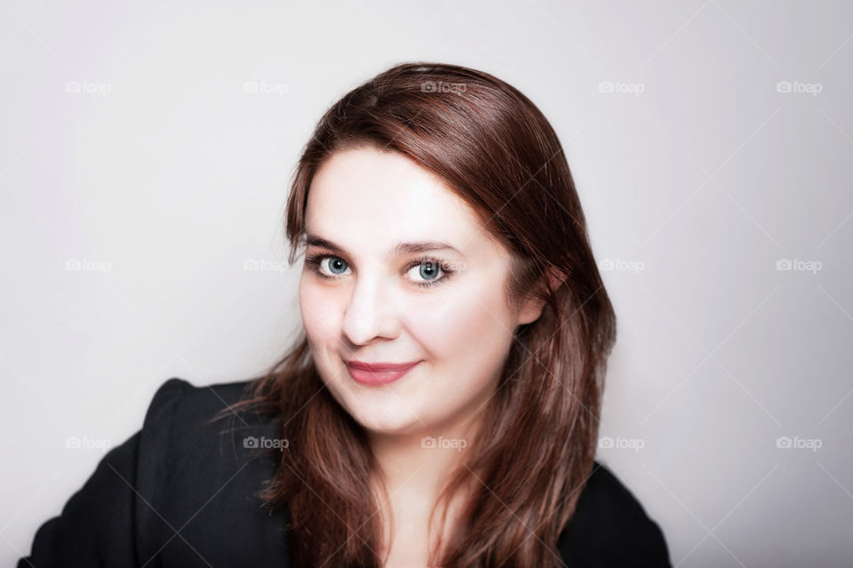 Studio portrait of pretty young woman looking into camera.