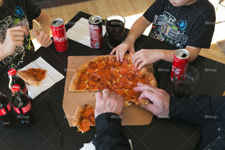 Pizza Coca-Cola potatoes. Big family. Grandfather and his grandsons 