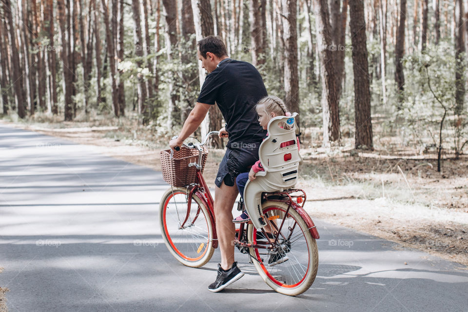 dad and daughter ride bicycles