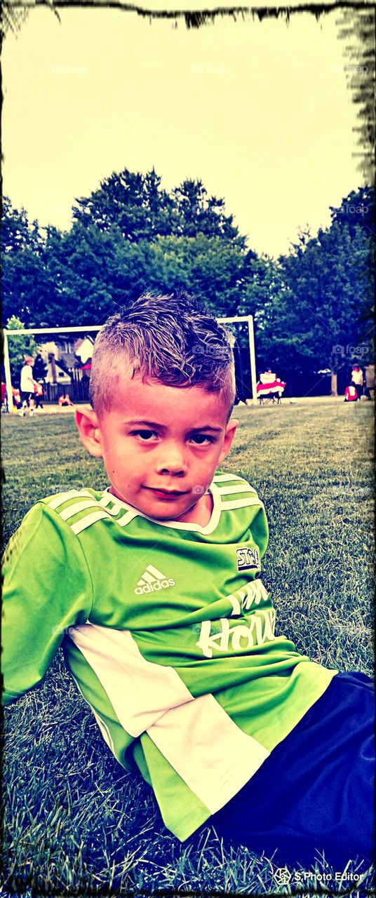 A young First Nations boy weights anxiously to play soccer.
