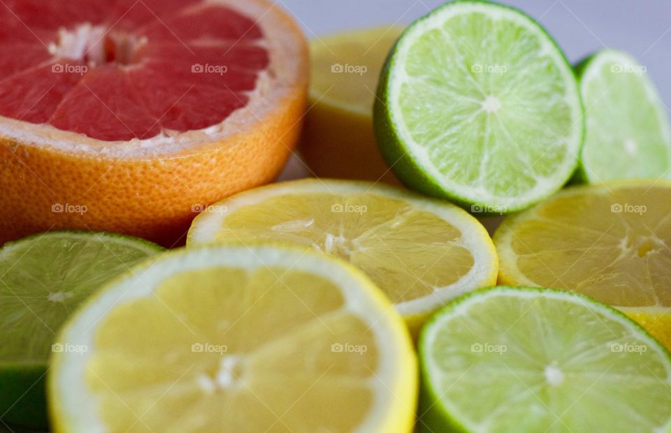 Still life of of grapefruit, lime and lemon halves on white background