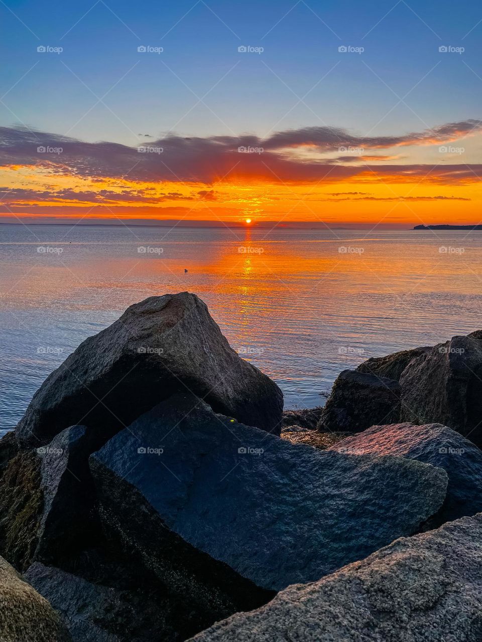 “Breakwater Fire.”  A sunrise viewed from the harbor breakwater displays fiery colors over the Atlantic.