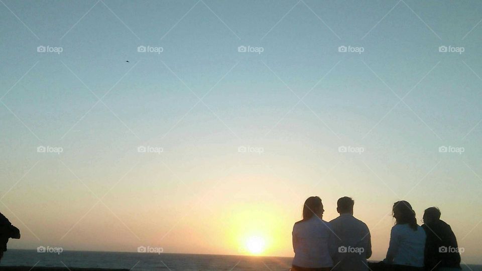 Two couples are looking at magic moment of sunset at essaouira city in Morocco