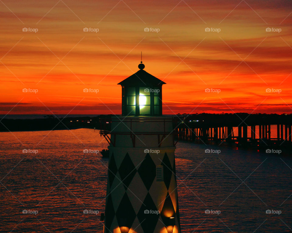 BEST PHOTO OF 2016! This Harbor walk Lighthouse stands tall and casts its beacon miles into the choppy, and salty ocean! The windows have the effect of being a brilliant star in a magnificent crimson sky. The harbor, protected by breakwaters, with this lighthouse at the entrance, is well defended from the north winds,but those from the south,southeast, and southwest prove sometimes highly  dangerous!