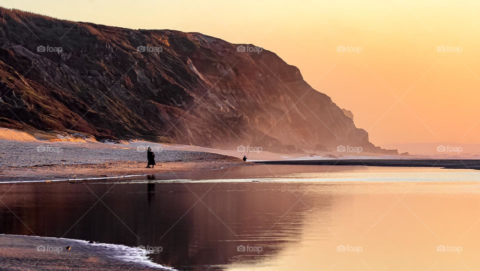 People enjoy sunset on the beach, next to the cliffs at Pataias 