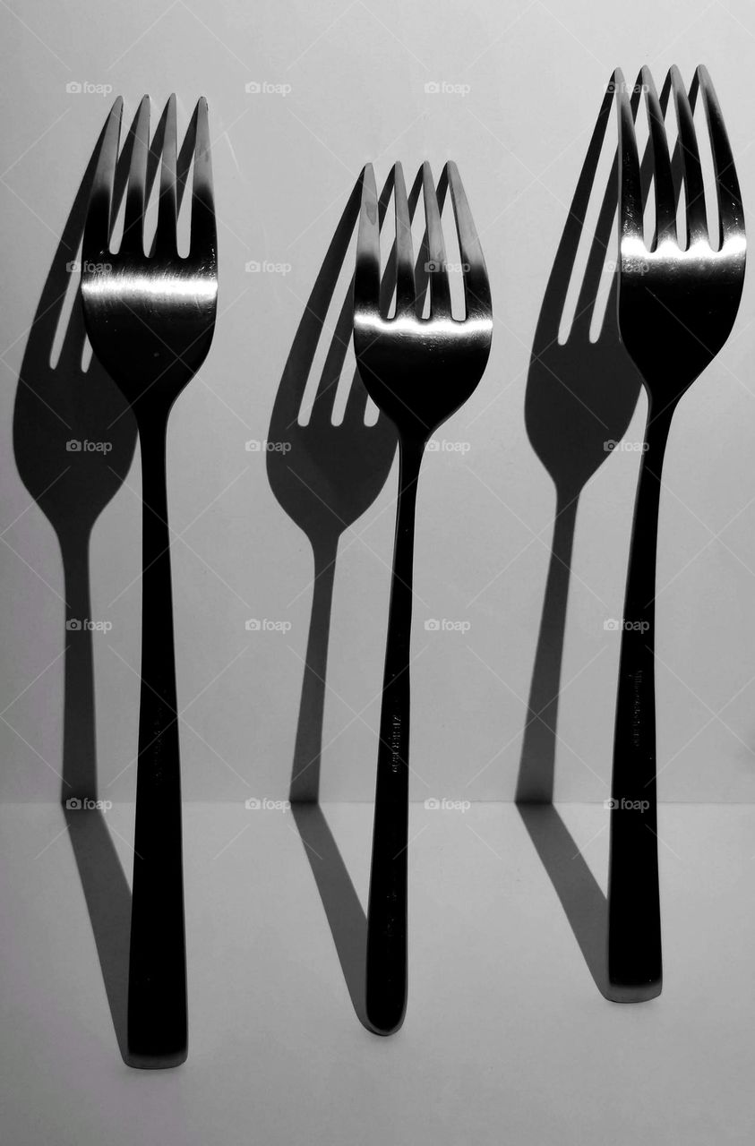 A kitchen fork and nice shadows. Three forks.