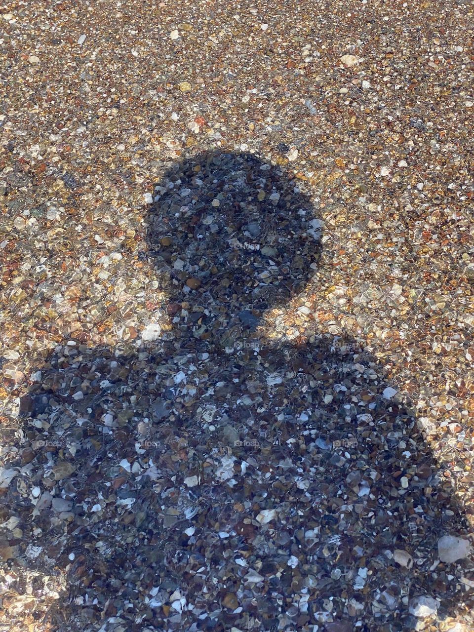 Shadow of woman with hat on beach