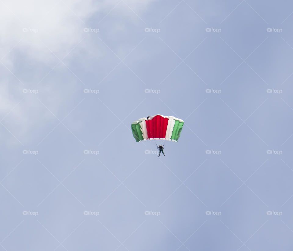 The parachute is flying against the blue sky. Parachuting.