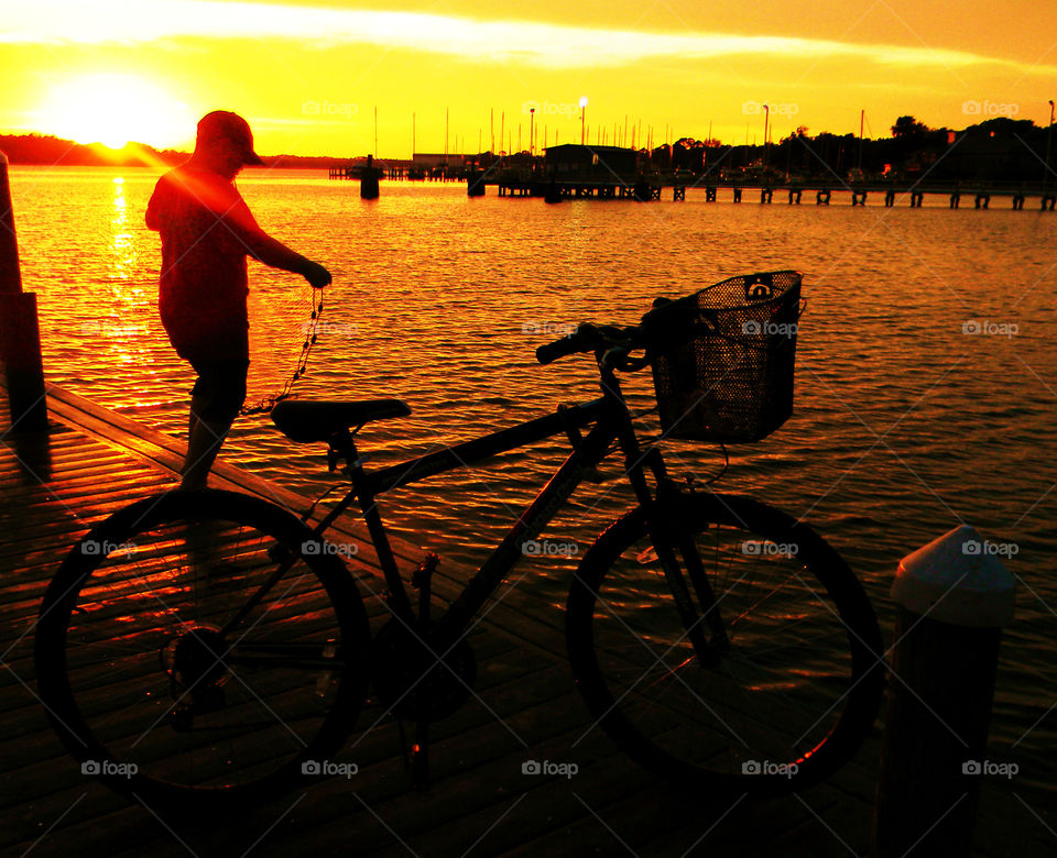 Boy and his bike. Boy fishing with bike by his side