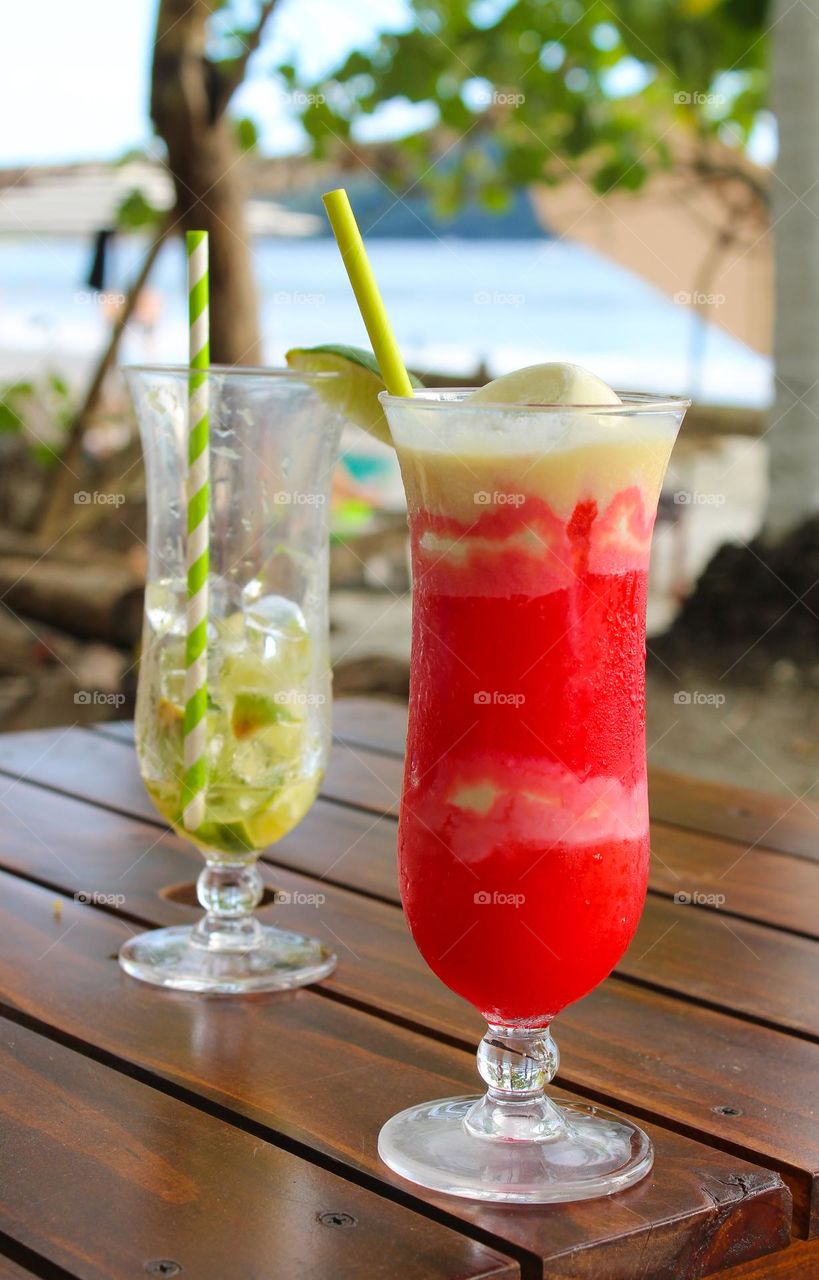 Two cocktails with exotic fruits and ice cream in the shade of a beautiful beach in Costa Rica