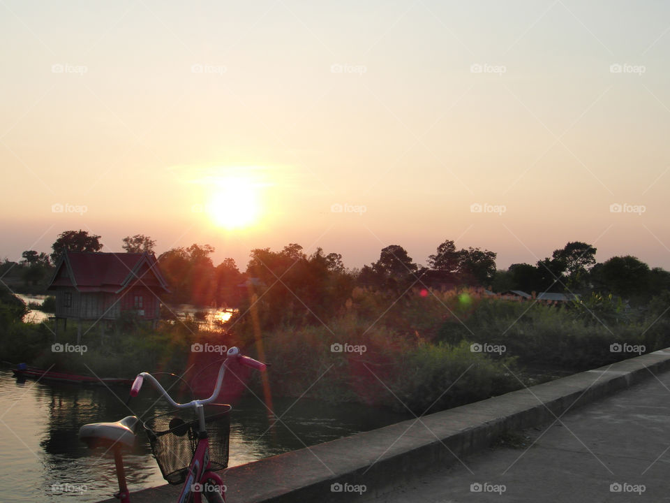 Bicycle in laos 4000islands on bridge at sunset.
