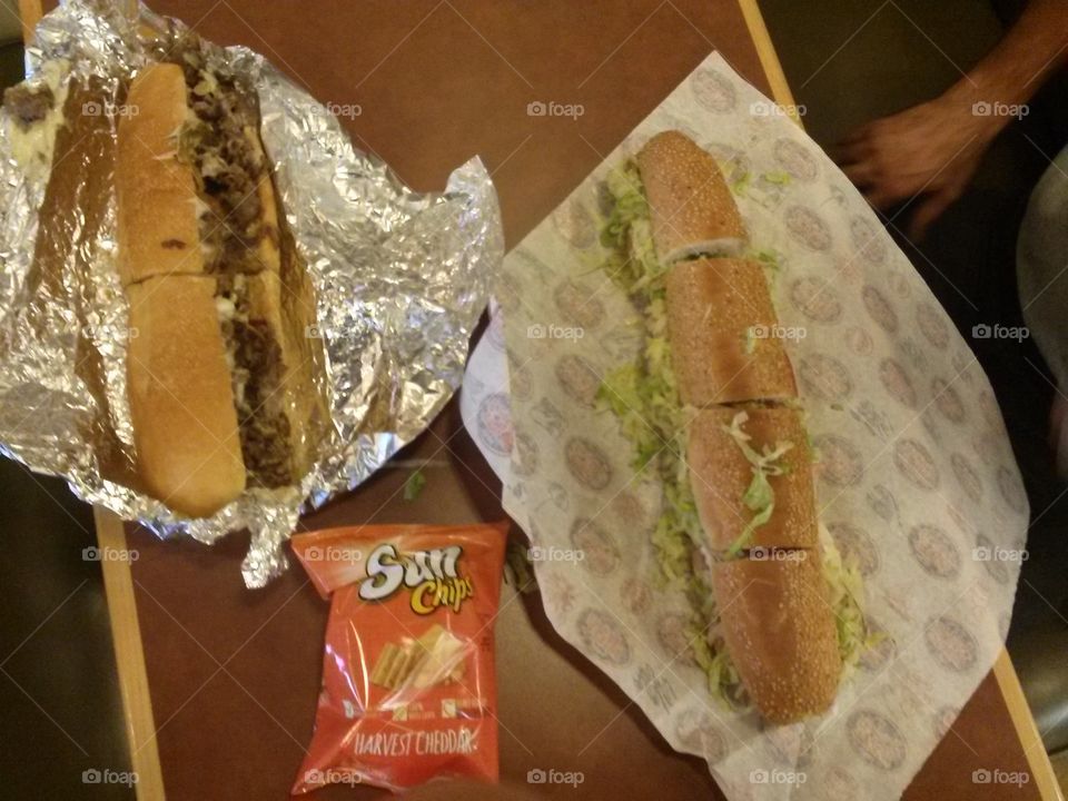 two delicious subs with chips