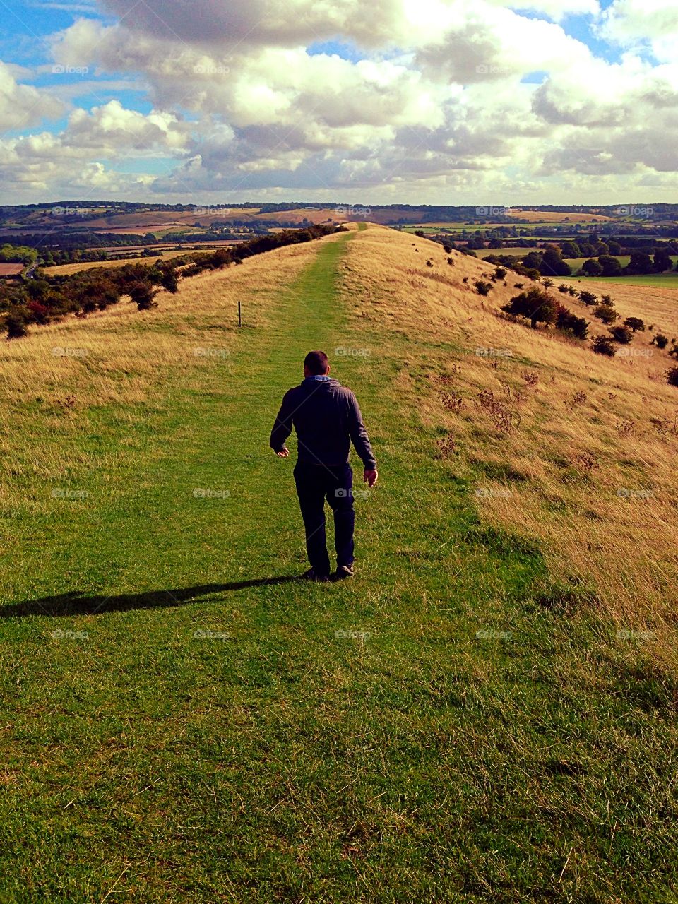 Lone man walking on hillside 