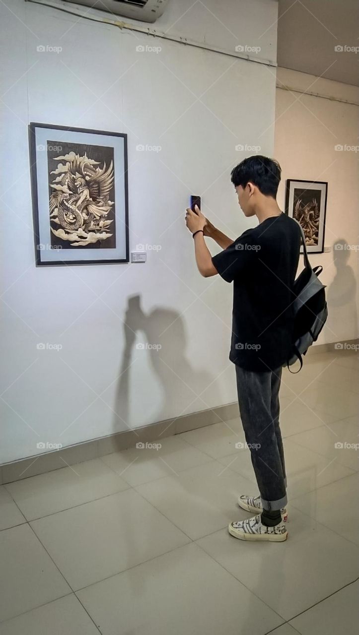 A young man is taking a photo in a frame