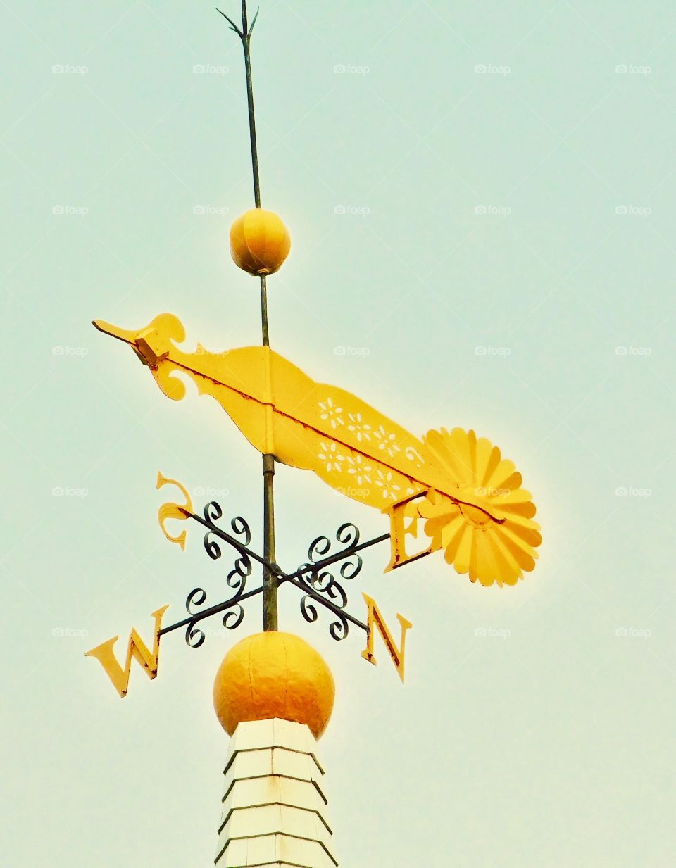 A yellow weather vane