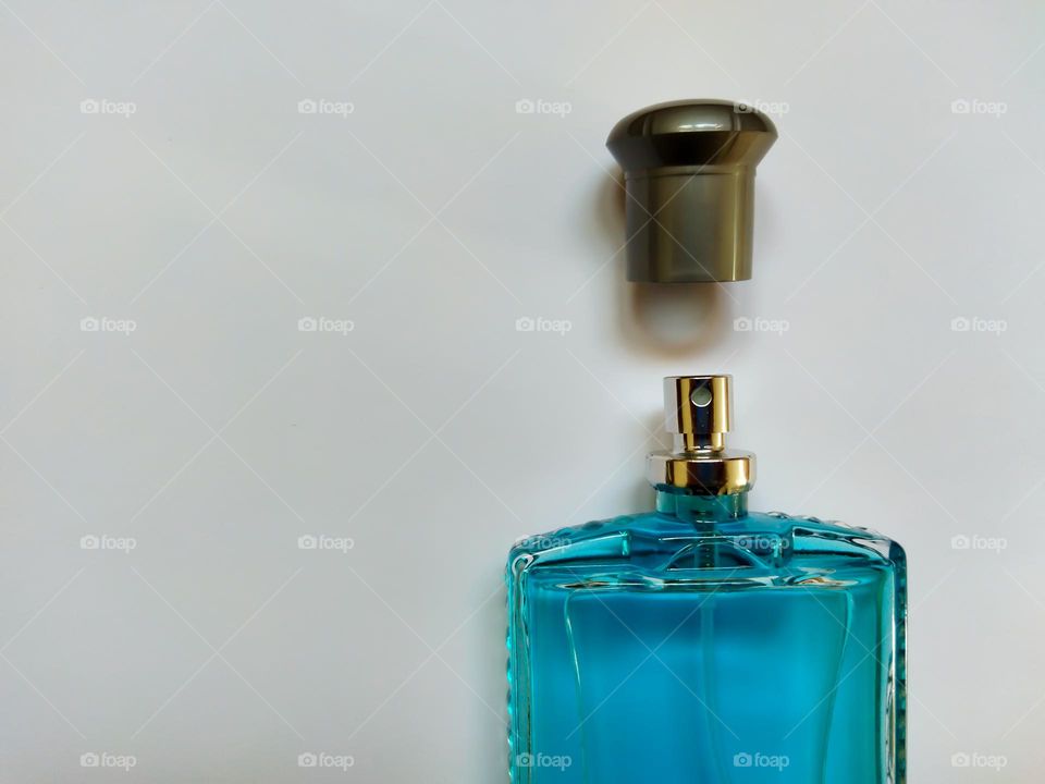 closeup of open glass perfume bottle on white background , negative space , minimal concept