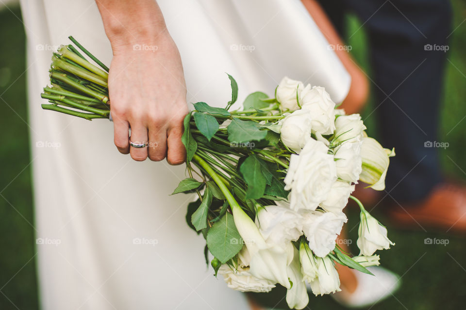 wedding bouquet of gorgeous white roses at bride's hand