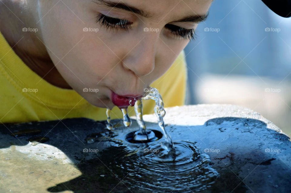 Child drinking water from a fountain