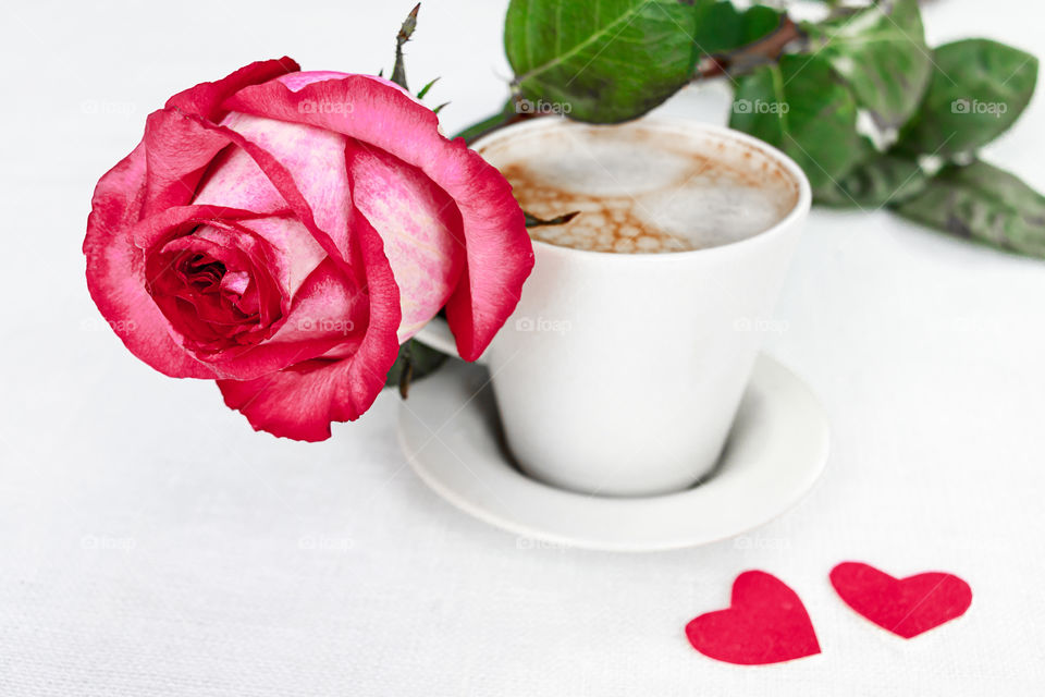 a cup of coffee and a rose