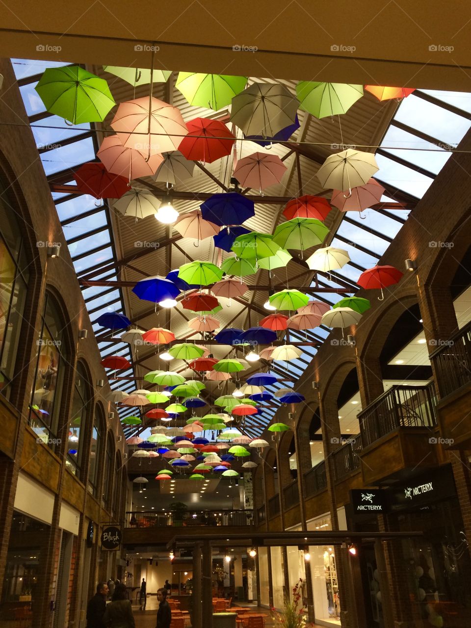 Creative display of umbrellas floating from the ceiling of a shopping center in Minneapolis are highlighted with clever use of lighting.
