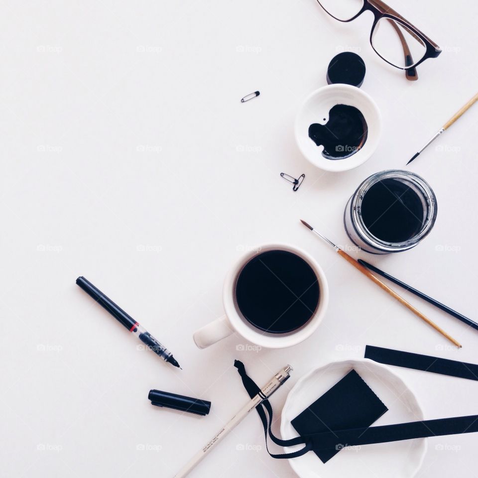 Desk from above . Workspace from above with black and white items 