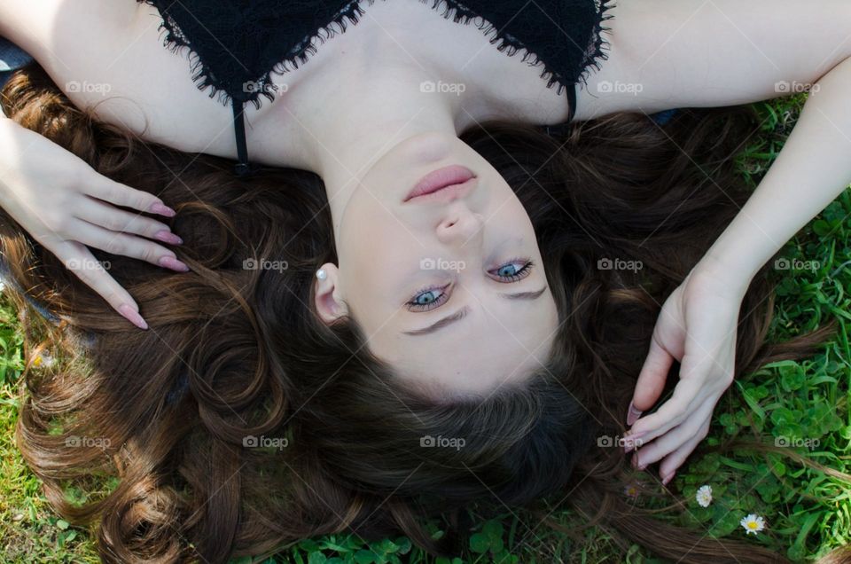 Portrait of Beautiful Young Girl on Background of Daisies