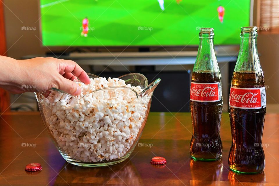 Enjoying football game with Coca Cola and popcorn
