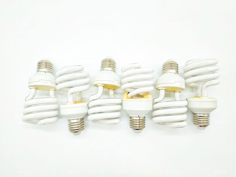 six energy-saving light bulbs lined in a row on a white background
