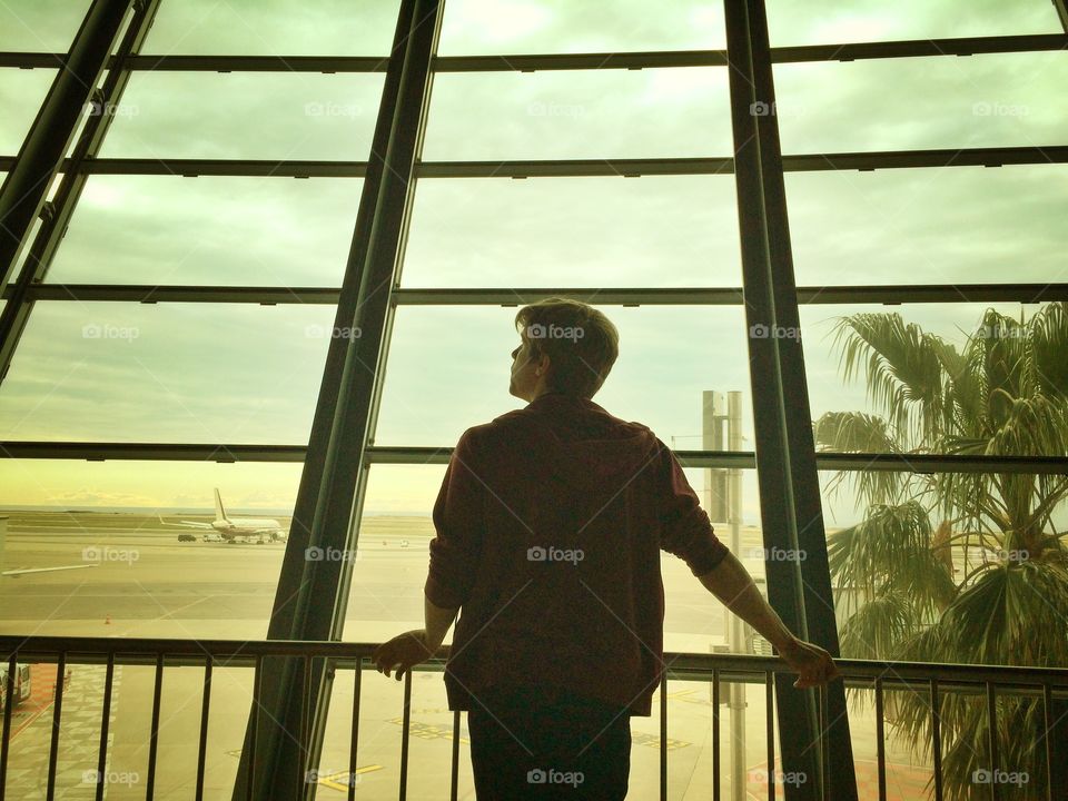 Waiting at the Nice, France Airport. Man waits at a tropical looking airport for a flight home.