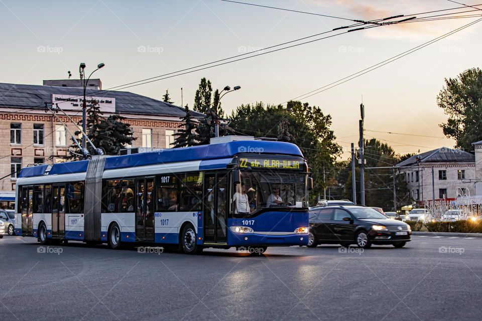 Blue trolleybus in traffic. Efficiency and environmental friendliness of transport.