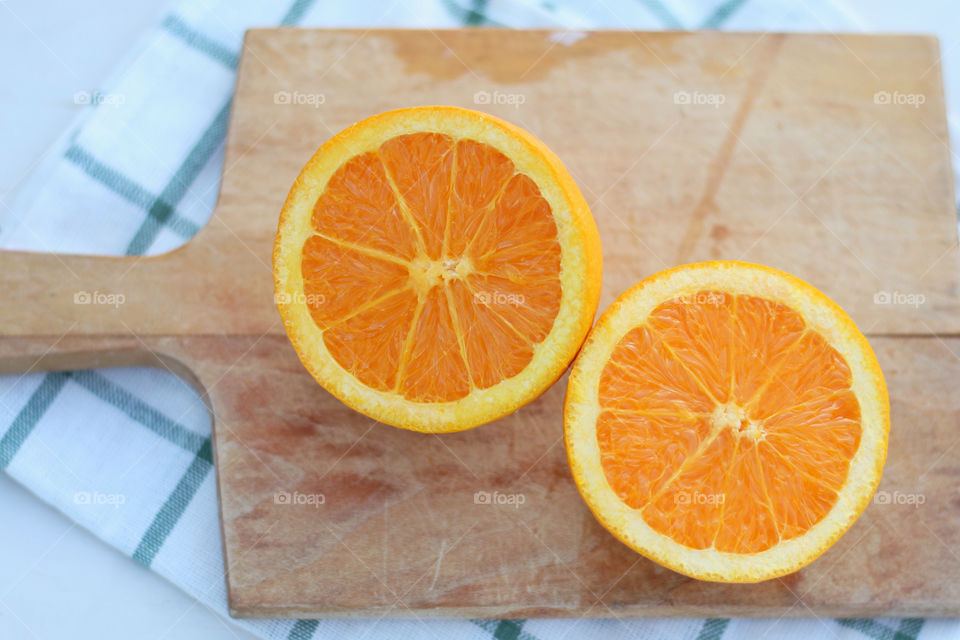 Orange halves on chopping board