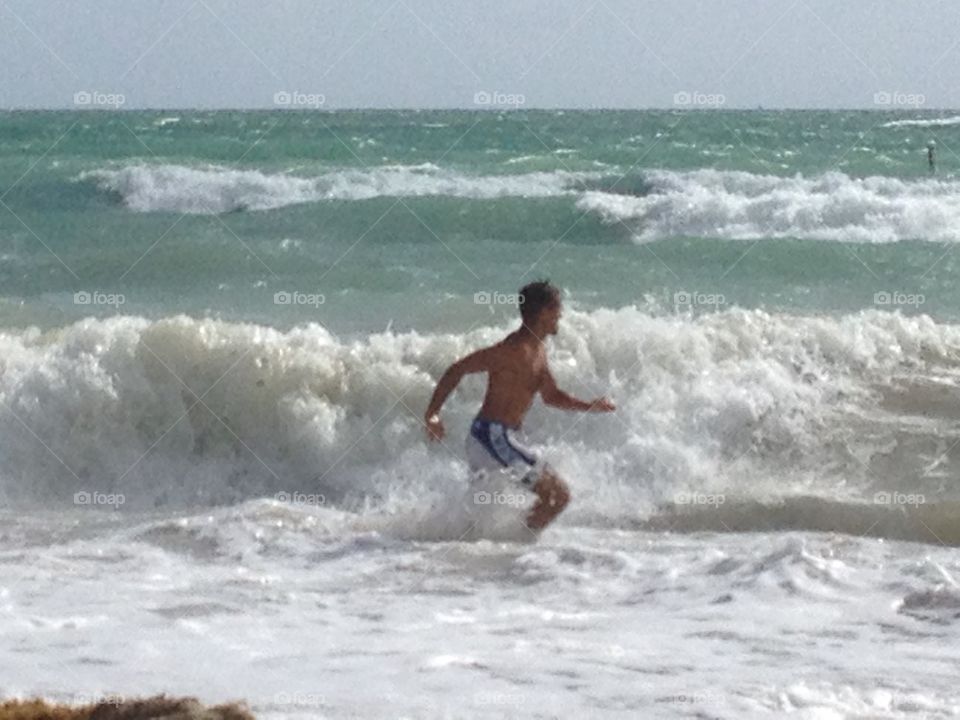 Man in the wave. Man is running in the Waves of the sea in Florida