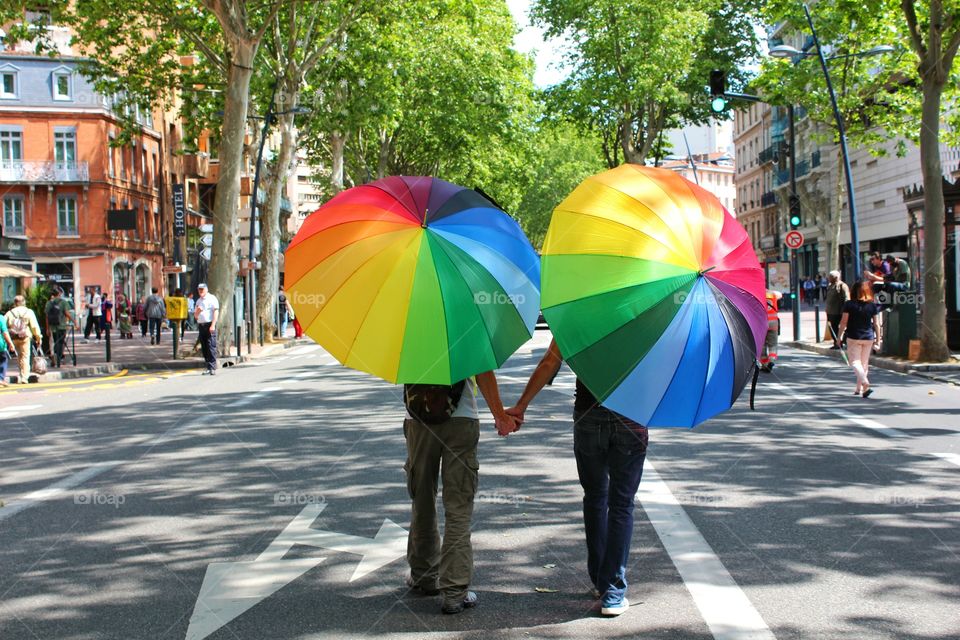 Rear view of two people with multi coloured umbrella