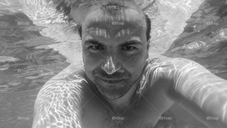 Close-up of a young man swimming under water
